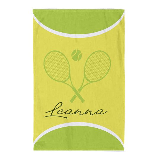 A personalized beach towel with a yellow and green tennis theme, featuring crossed tennis rackets, a tennis ball, and the name 'Leanna' in black script.