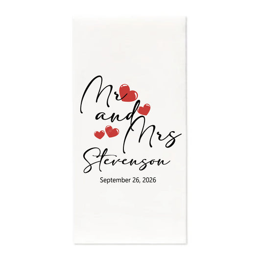 A white rectangular card or print with black script text reading 'Mr and Mrs Stevenson' and the date 'September 26, 2026', accented by small red hearts, shown on a light gray background.