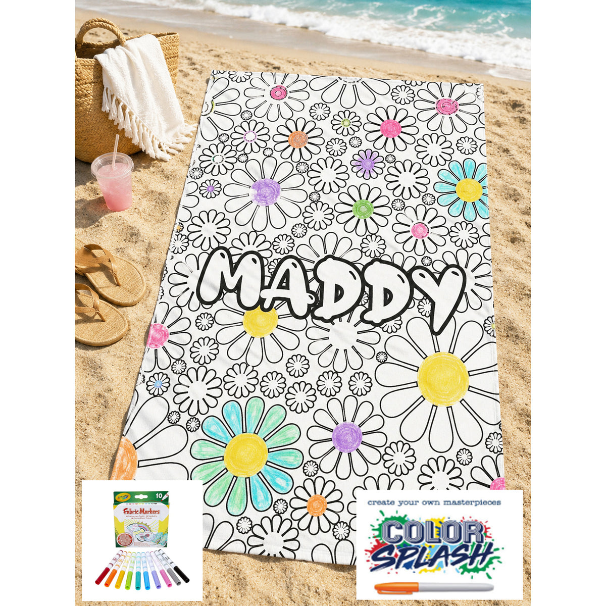 A personalized beach towel laid on a sandy beach, featuring a black-and-white daisy outline pattern with colorful flower centers and the name 'MADDY' printed across the middle. A straw hat, white towel, drink, flip-flops, and ocean are visible around it, plus small product graphic overlays at the bottom.