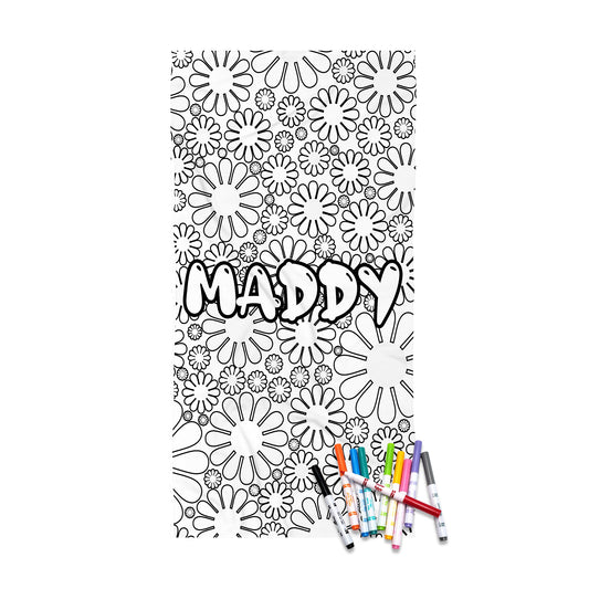 A black and white floral coloring page featuring the name 'MADDY' in bold outlined letters, shown with several colored markers at the bottom on a white background.