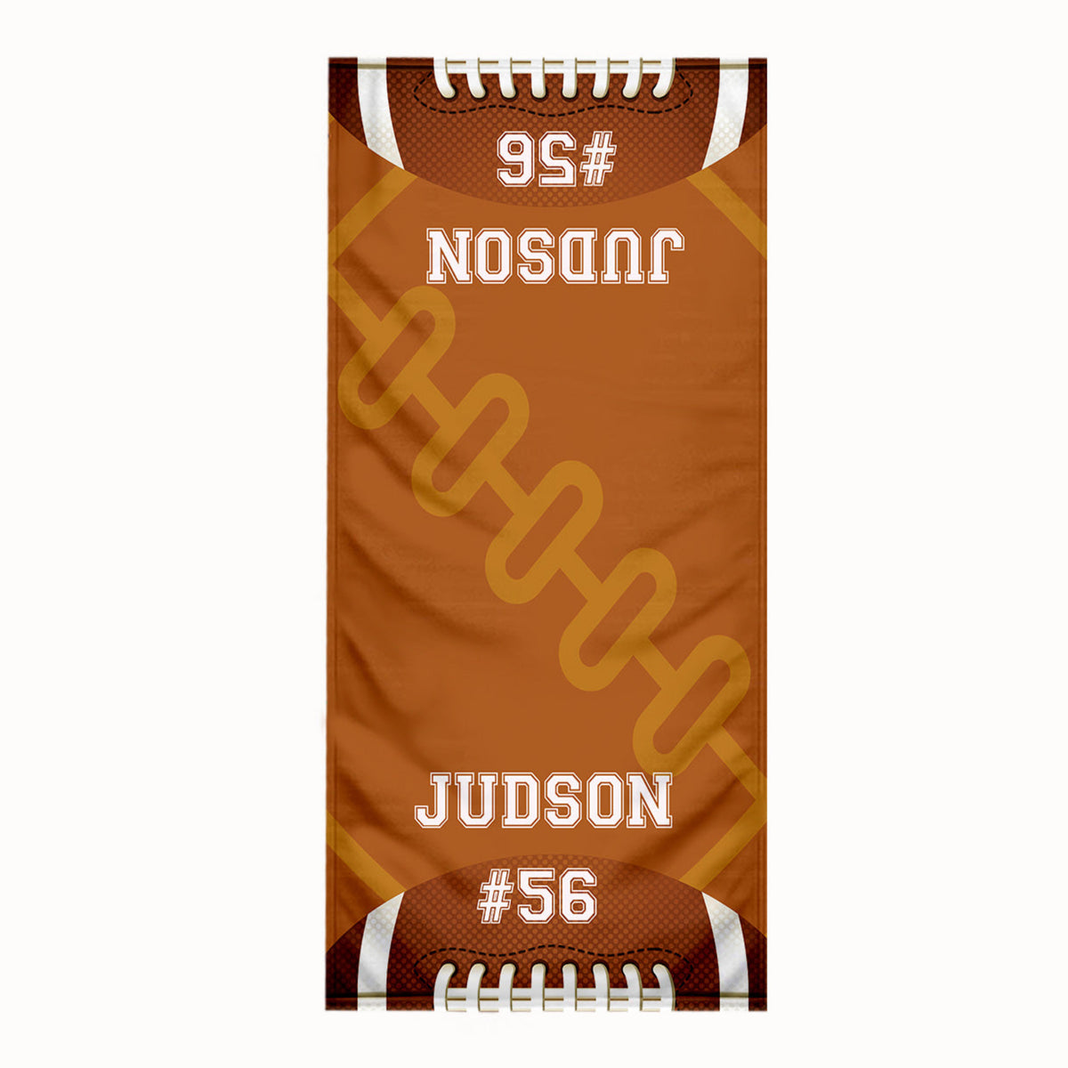 A custom football-themed beach towel featuring a brown and orange design with white laces, a football pattern, and the text 'JUDSON #56' printed on it.