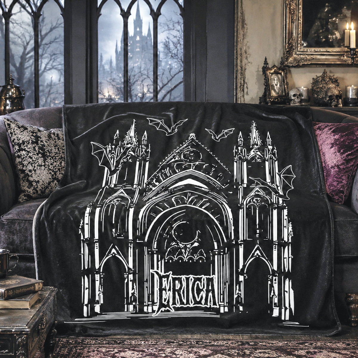 A black throw blanket draped over a dark sofa in a gothic-style room, featuring a large white line-art illustration of a cathedral with bats and the word 'PERICA' across the center.
