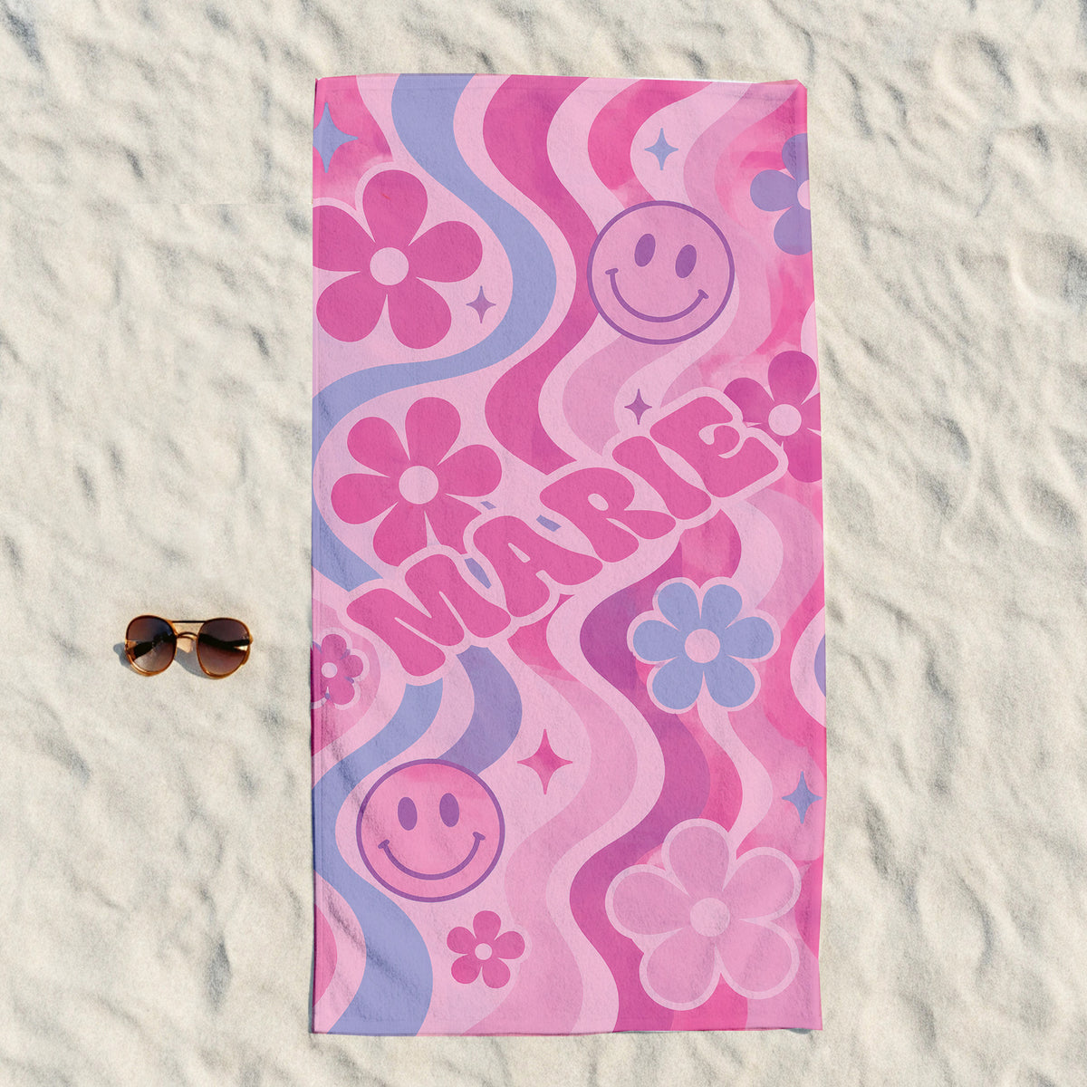 Colorful PInk beach towel with pink smily faces, pink and blue flowers on light pink background