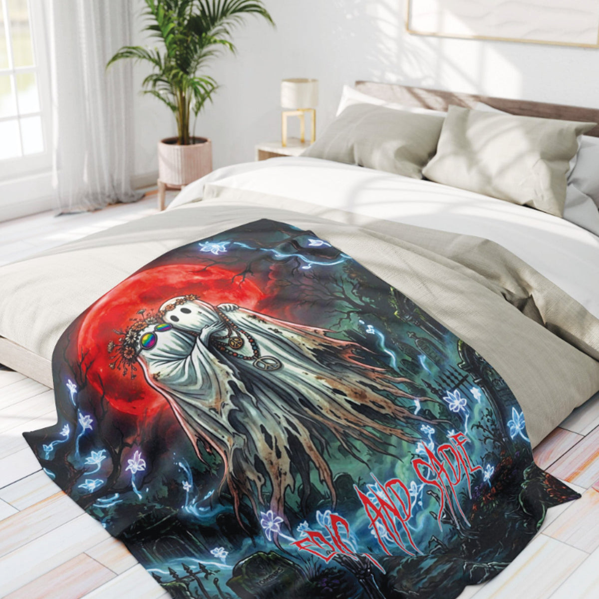 A printed duvet cover or comforter spread across a bed in a bright bedroom. The design shows a ghostly figure in front of a large red moon with blue lightning and dark scenery, plus stylized text reading 'SCARE AND LOVE'.