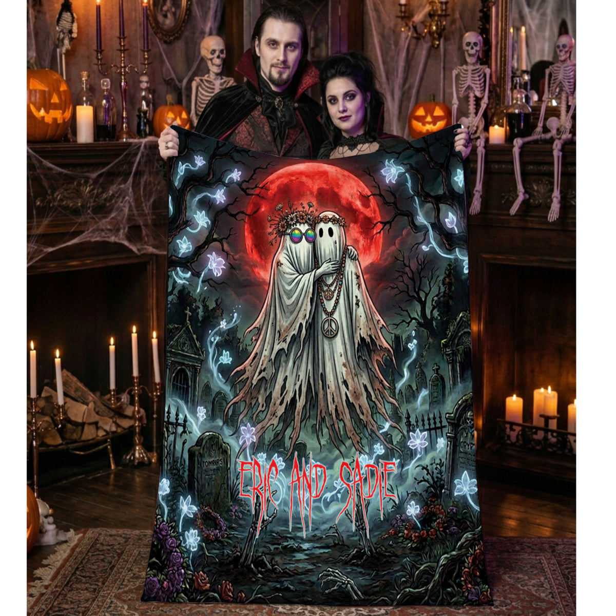 A couple holds up a Halloween-themed blanket featuring a spooky graveyard scene with two ghosts, a red full moon, and the text 'CRAZY NOISE'. The background shows a decorated Halloween room with skeletons, candles, and jack-o'-lanterns.