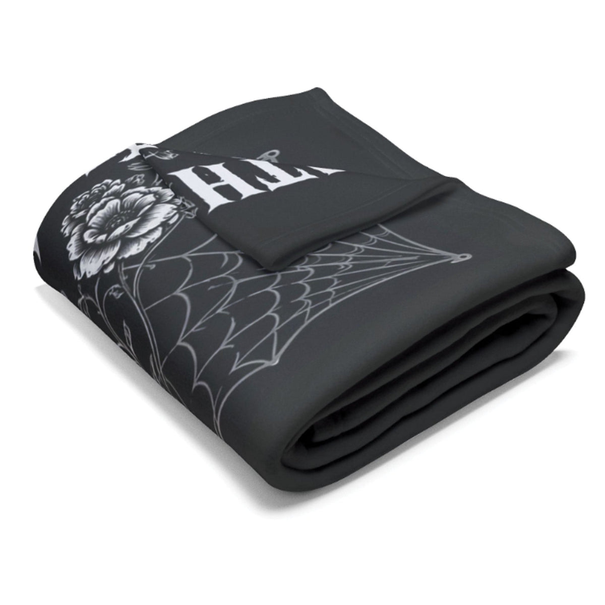A folded black blanket featuring a white gothic-style graphic print with a spiderweb, a flower, and the word 'HELL' in a bold font, set against a plain white background.