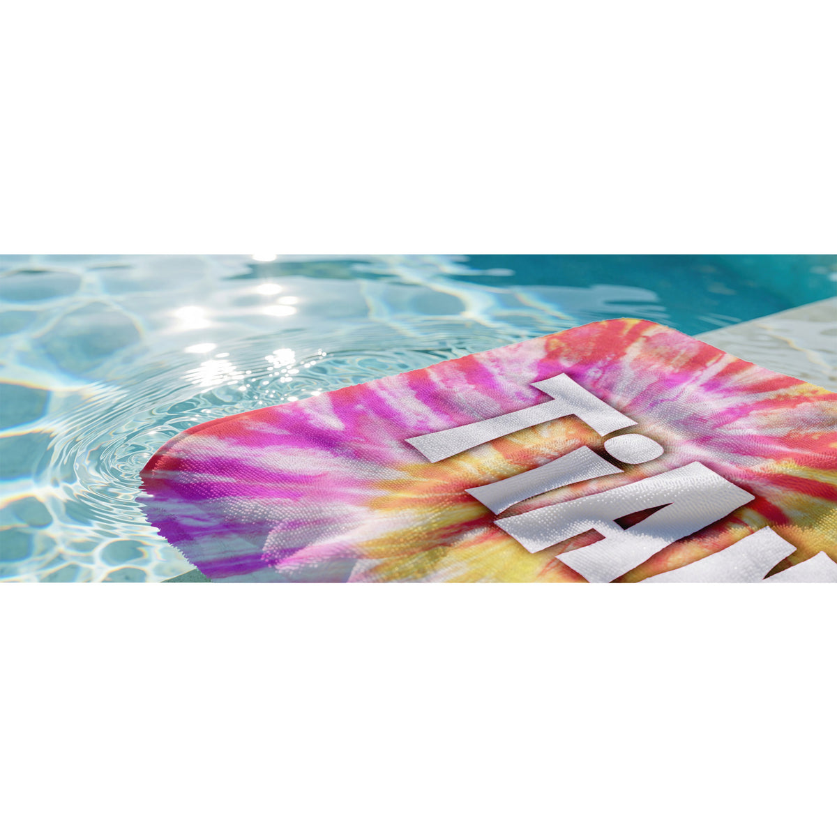Beach towel with pale orange and pale pink tye die design with name maddy in a bubbly retro font in water