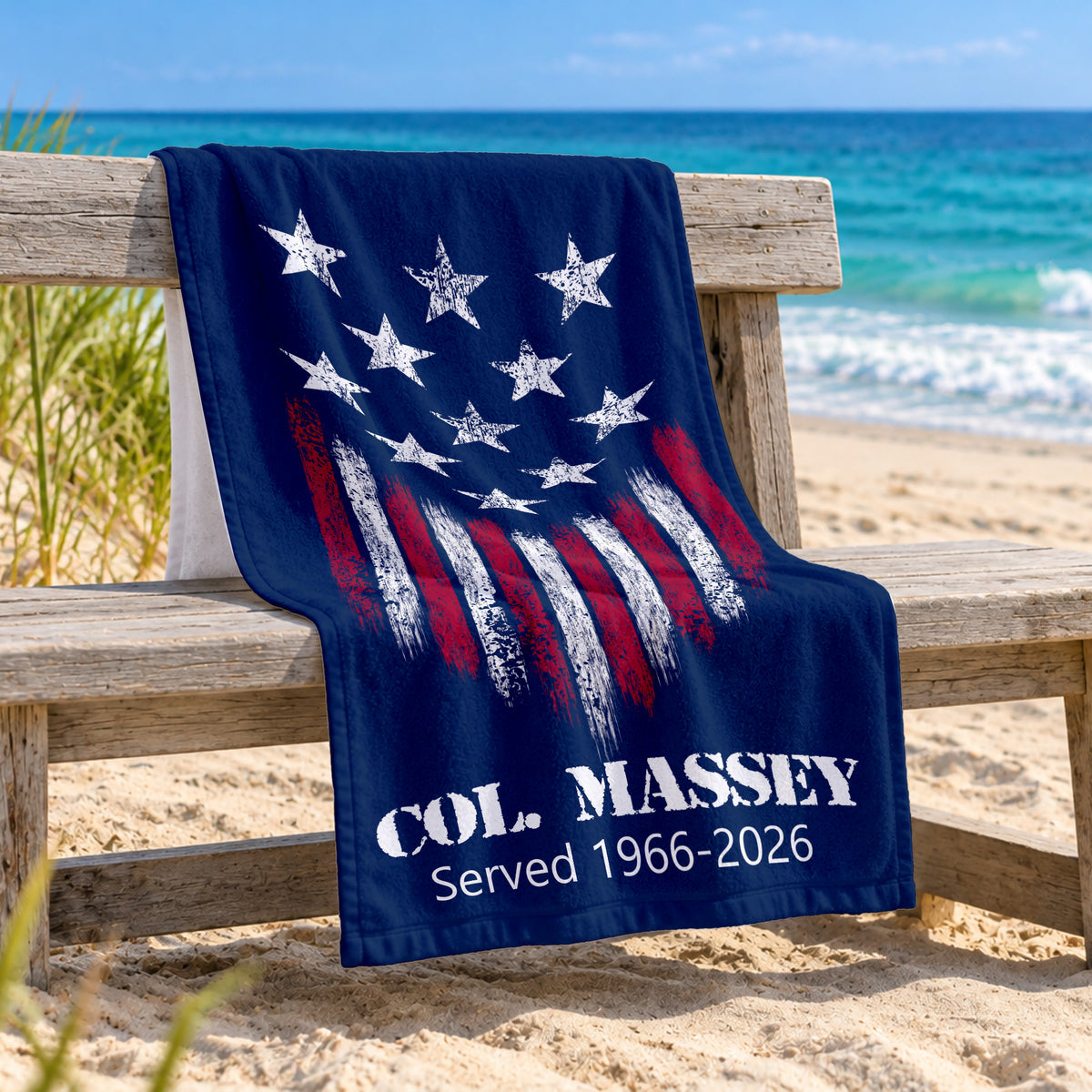 navy blue towel with white stars and red and white stripes with Col Massey and served from 1966-2026 underneath at the bottom