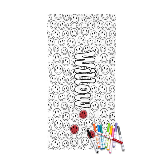 A rectangular white item printed with a repeating black smiley face pattern, a large vertical wavy black outline reading 'momma' in the center, and two small red smiley faces near the bottom. Several colored markers are placed at the lower right corner, suggesting a product mockup or gift presentation.