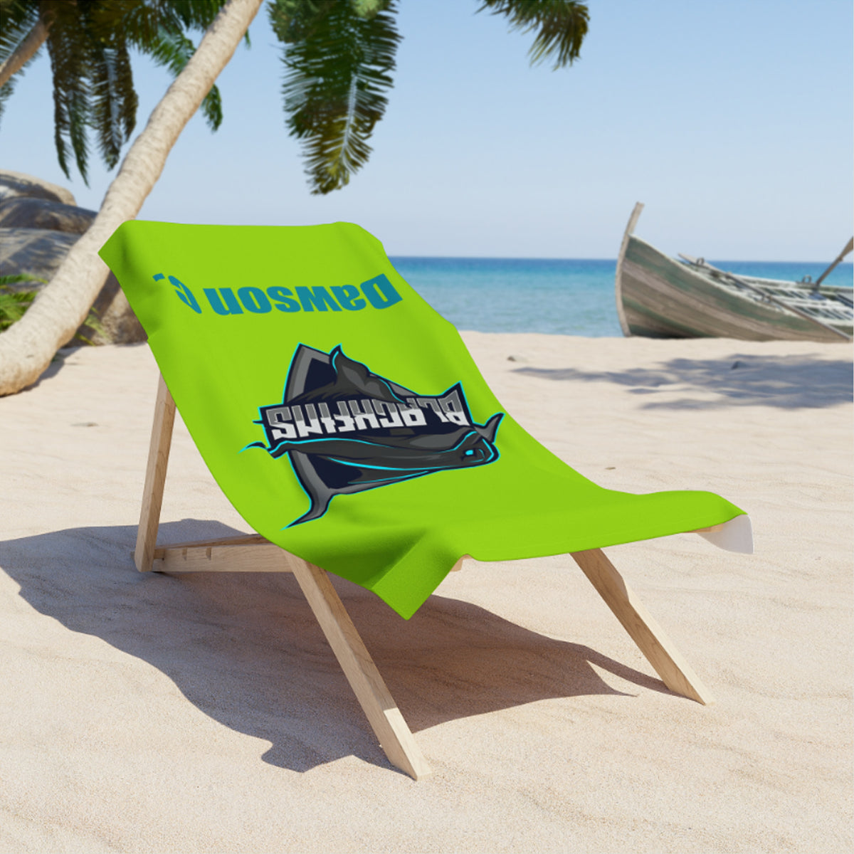 A bright lime green beach towel draped over a wooden lounge chair on a sandy beach. The towel features a dark blue and black marlin graphic with the text 'SHARKS' and a mirrored 'Dawson' logo.