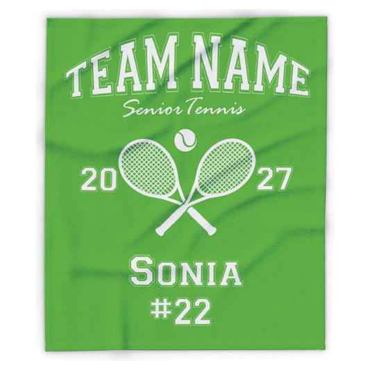 A green custom-printed blanket featuring white text and graphics for a senior tennis team, including 'TEAM NAME', 'Senior Tennis', crossed rackets, a tennis ball, numbers '20' and '27', the name 'SONIA', and the number '#22'.