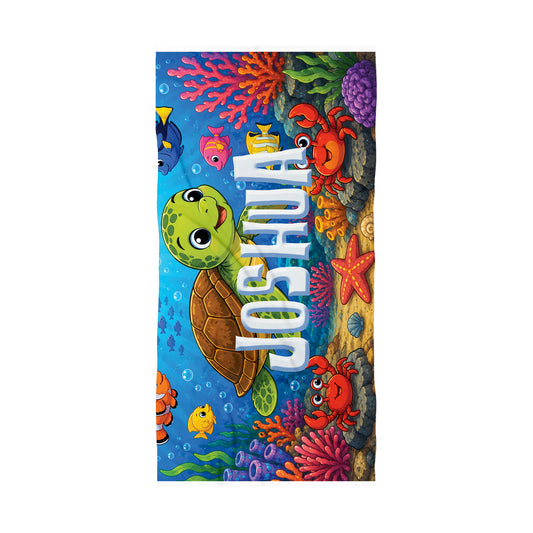 A personalized beach towel featuring a colorful cartoon sea turtle, crab, starfish, and coral reef design with the name 'JOSHUA' printed vertically in large white letters, shown on a plain white background.