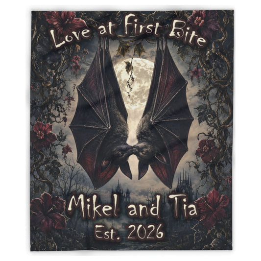 A square custom gothic-themed blanket or tapestry featuring an illustration of two kissing bats in front of a full moon, surrounded by dark roses and vines. The text reads 'Love at first Bite' at the top and 'Mikel and Tia Est.
